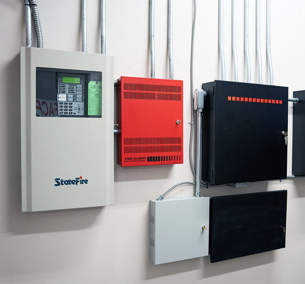 Commercial fire alarm control panels and power supply equipment installed on a facility wall.